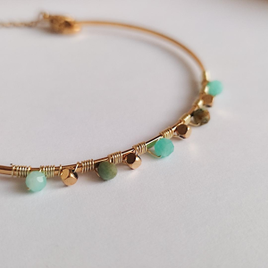 Craquez pour ce jonc ajustable doré qualité 3 microns. Orné de perles facettées vert d'eau style bohème. Un bijou fin, durable et réglable pour tous les poignets.
