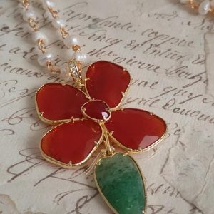 Sautoir chaine perles avec pendentif fleur en cornaline et médaillon amovible. Pierre naturelle rouge, détail vert, finition acier dorée. By Selma Paris. Livraison offerte dés 69€