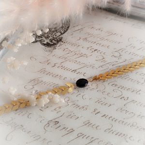 Bracelet doré en acier inoxydable 3 microns, composé d’une chaîne motif épi et d’une pierre ovale noire centrale. Élégant et féminin, Livraison dés 69€