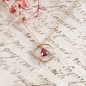 L’élégance du noir et de l’or : découvrez notre collier fin anneau et goutte couleur grenat en acier doré 3 microns. Un bijou minimaliste et lumineux, idéal pour offrir.